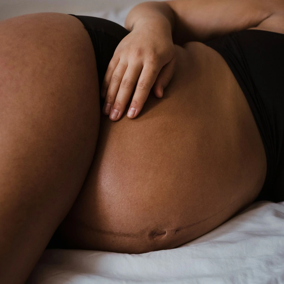 a woman in a black bikini laying on a bed
